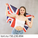Girl holds unfolded canvas flag of Great Britain in front of her. Стоковое фото, фотограф Яков Филимонов / Фотобанк Лори