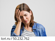 Frustrated woman holding head in hands and expressing pain. Стоковое фото, агентство Ingram Publishing / Фотобанк Лори