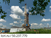 Drilling a well in an oil field. Mobile drilling rig and drilling equipment. Summer. Beautiful sky and nature. Стоковое фото, фотограф Владимир Ендовицкий / Фотобанк Лори
