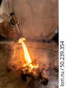 Cooking of beef teppanyaki recipe japanese grilled beef on cooking pan with scraper and gas burner flame. Стоковое фото, агентство Ingram Publishing / Фотобанк Лори