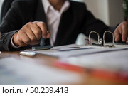 Businessman hand pressing rubber stamp approved on business contract document. Стоковое фото, агентство Ingram Publishing / Фотобанк Лори