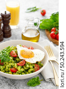 Pasta cavatappi with spinach pesto, tomatoes and fried egg in bowl served for lunch. Стоковое фото, агентство Ingram Publishing / Фотобанк Лори
