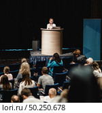 Female speaker giving a talk on corporate business conference. Unrecognizable people in audience at conference hall. Business and Entrepreneurship event. Стоковое фото, фотограф Matej Kastelic / Фотобанк Лори