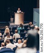 Female speaker giving a talk on corporate business conference. Unrecognizable people in audience at conference hall. Business and Entrepreneurship event. Стоковое фото, фотограф Matej Kastelic / Фотобанк Лори