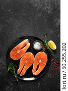 Fresh raw salmon fish steaks with cooking ingredients on kitchen table, healthy food, source of omega-3. Стоковое фото, агентство Ingram Publishing / Фотобанк Лори