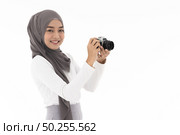 Portrait of happy young adult asian muslim fenale tourist and photographer holding a camera and smiling. Studio shot of woman isolated on white background. Стоковое фото, агентство Ingram Publishing / Фотобанк Лори