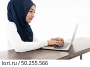 Asian young adult woman wearing hijab using laptop search and doing office work isolated in white background - office, business, finance and work station concept. Стоковое фото, агентство Ingram Publishing / Фотобанк Лори