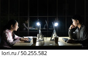Young adult asian businessman and woman working late at night in their office with desktop computer and laptop. Using as hard working and working late concept. Стоковое фото, агентство Ingram Publishing / Фотобанк Лори
