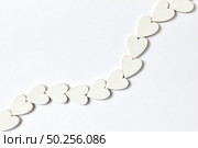 Curve diagonal chain made from handcraft paper Valentine’s hearts on a light grey background with soft shadows, copy space. Flat lay.. Hearts decoration in the shape of chain with soft shadows. Стоковое фото, агентство Ingram Publishing / Фотобанк Лори