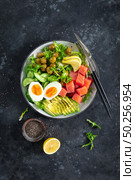 Ketogenic, paleo diet lunch bowl with salted salmon fish, lemon, avocado, olives, boiled egg, cucumber, green lettuce salad and chia seeds, healthy food trend, top view. Стоковое фото, агентство Ingram Publishing / Фотобанк Лори