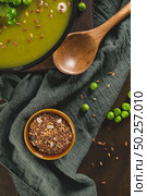 Green pea soup with linseed and pumpkin and sunflower seeds on a rustic kitchen countertop. Стоковое фото, агентство Ingram Publishing / Фотобанк Лори