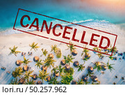 Travel and holidays cancelled due to epidemic of coronavirus. Tourism and resort cancelation due to Covid-19. Aerial view of beautiful tropical sandy beach, palm trees, blue sea in summer and text. Стоковое фото, агентство Ingram Publishing / Фотобанк Лори