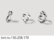 Set of stainless steel cookie-cutters for baking homemade christmas cookies, in the shape of stars and gingerbread on a light grey background with soft shadows.. Vertically standing stainless steel moulds set for cookies. Стоковое фото, агентство Ingram Publishing / Фотобанк Лори