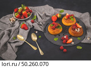 Caramel custard puddings on round slate on and dark kitchen countertop. Стоковое фото, агентство Ingram Publishing / Фотобанк Лори