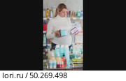Young pregnant woman in store carefully examining packs of panty liners, selecting best option for daily comfort and freshness during pregnancy. Стоковое видео, видеограф Яков Филимонов / Фотобанк Лори