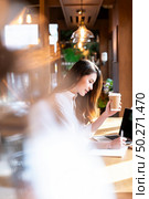 Quarantine Young asian woman wearing smart casual clothes work at home in living room using laptop and drinking hot coffee and croissant while city  lockdown for covid-19 corona virus pandemic. Стоковое фото, агентство Ingram Publishing / Фотобанк Лори