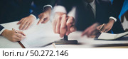 Close-up Of A Person’s Hand Stamping With Approved Stamp On Document At Desk, management approval banner background. Стоковое фото, агентство Ingram Publishing / Фотобанк Лори