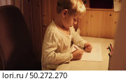 Toddler Child Drawing Sitting At Table. Activities to Foster Creativity in a Cozy Home Setting. Young kid boy diligently focused on his vibrant drawing. Imagination. Happy little boy coloring. Стоковое видео, видеограф Марина Демидюк / Фотобанк Лори