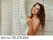 Portrait cute young woman in bathroom at home shows thumb up gesture. Стоковое фото, фотограф Aleksandr Golubev / Фотобанк Лори