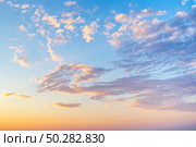Sky with wispy cirrus clouds illuminated by the setting sun in soft orange tones. Celestial landscape. Стоковое фото, фотограф Коханова Наталья / Фотобанк Лори