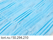 Diagonally arranges medical antibacterial protective blue face masks as a health-care background. Concept of prevention from respiratory sickness and viruses.. Creative backdrop from protective medical masks. Top view. Стоковое фото, агентство Ingram Publishing / Фотобанк Лори