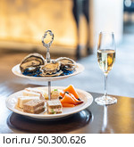 Welcome cocktail Canapes dish, Fresh Oyster and smoked salmon seafood dish with sparkling champagne. Appetizer dish before groumet brunch buffet international cuisine. Стоковое фото, агентство Ingram Publishing / Фотобанк Лори