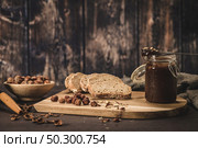 Vegan chocolate spread made of organic almond butter and organic cacao and honey, on dark rustic kitchen counter top. Стоковое фото, агентство Ingram Publishing / Фотобанк Лори