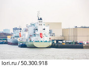 Big Cargo Containers Boat with Goods cargo Stack at the Pier docks port waiting for international sea freight transportation in Rotterdam Port of Netherlands. Стоковое фото, агентство Ingram Publishing / Фотобанк Лори