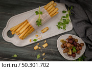 Fresh baked homemade grissini bread sticks in white ceramic tray with olive oil and basil herbs over kitchen counter top. Стоковое фото, агентство Ingram Publishing / Фотобанк Лори