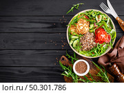Lunch bowl with buckwheat porridge, fried chicken cutlets and fresh vegetable salad of arugula, lettuce, chard leaves, tomato, cucumber and flax seeds. Стоковое фото, агентство Ingram Publishing / Фотобанк Лори