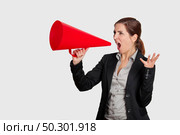 Business young woman speaking to a megaphone, isolated on white. Стоковое фото, агентство Ingram Publishing / Фотобанк Лори