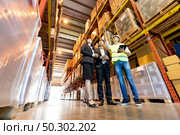 Portrait of engineer manager giving tour two businessman to inspect factory warehouse and discuss about warehouse inventory. Owner Investor Business deal and teamwork concept. . Стоковое фото, агентство Ingram Publishing / Фотобанк Лори