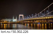 Night view to Budapest Inner-City Mother Church of the Blessed Virgin and Elisabeth Bridge across river Danube with lighting Budapest, Hungary.. Elisabeth Bridge across river Danube with night lighting, Budapest. Стоковое фото, агентство Ingram Publishing / Фотобанк Лори