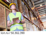 Portrait white caucasian warehouse worker stand with digital tablet for inventory checking in large warehouse distribution center. Reopening  Business warehouse technology and logistic concept. Стоковое фото, агентство Ingram Publishing / Фотобанк Лори