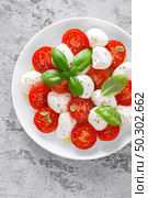Caprese salad. Salad with mozzarella cheese fresh tomatoes, basil leaves and olive oil. Italian food. Стоковое фото, агентство Ingram Publishing / Фотобанк Лори