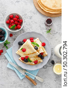 Thin crepes with fresh berries and lemon zest. Pancakes with raspberry and blackberry. Стоковое фото, агентство Ingram Publishing / Фотобанк Лори