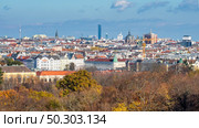 Wonderful urban landscape with roofs of historic and modern buildings in Vienna, Austria with autumn trees without leaves on a forefront on a blue cloudy background.. Urban landscape with roofs of historic and modern buildings in Vienna. Стоковое фото, агентство Ingram Publishing / Фотобанк Лори