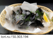 Fresh black mussel seafoon in basket with lemon. Fresh food and market concept. Стоковое фото, агентство Ingram Publishing / Фотобанк Лори
