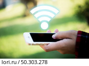 Woman’s hand holding mobile smart phone with wifi connecting screen. Стоковое фото, агентство Ingram Publishing / Фотобанк Лори