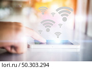 Woman’s hand touching mobile smart phone with wifi connecting screen. Стоковое фото, агентство Ingram Publishing / Фотобанк Лори