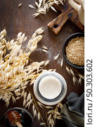 Vegan oat milk in glass bottle and ingredients for cooking. Healthy vegetarian non-dairy drink or beverage. Alternative milk. Стоковое фото, агентство Ingram Publishing / Фотобанк Лори