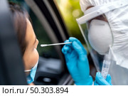 Portrait of asian woman drive thru coronavirus covid-19 test by medical staff with PPE suit by nose swab. New normal healthcare drive thru service and medical concept. Стоковое фото, агентство Ingram Publishing / Фотобанк Лори