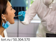 Medical staff with PPE suit test coronavirus covid-19 to asian woman by throat swab at home. New normal health care service at home and medical delivery and COVID-19 testing concept. Стоковое фото, агентство Ingram Publishing / Фотобанк Лори