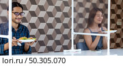 Panoramic two asian influencer food blogger or vlog show food at new normal social distance restaurant with table shiled partition. Restaurant new normal lifestyle and food influencer concept. Стоковое фото, агентство Ingram Publishing / Фотобанк Лори