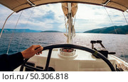 Ship control panel with steering wheel on the captain bridge. Men’s hand controls the yacht. Ship control panel with steering wheel on the captain bridge. Стоковое фото, агентство Ingram Publishing / Фотобанк Лори