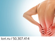 Man is touching his back because it aches. Стоковое фото, агентство Ingram Publishing / Фотобанк Лори