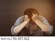 Sad man holding head with hand. Стоковое фото, агентство Ingram Publishing / Фотобанк Лори