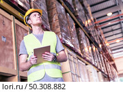 Portrait white caucasian warehouse worker use digital tablet for inventory check in large warehouse distribution center. Reopening traditional business warehouse and logistic concept. Стоковое фото, агентство Ingram Publishing / Фотобанк Лори