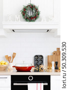 Christmas home kitchen interior with wooden worktop and kitchenware, holiday cooking background. Стоковое фото, агентство Ingram Publishing / Фотобанк Лори