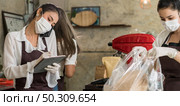 Panoramic Asian waitress take order from mobile phone for takeout or curbside pickup orders while city lockdown. They wear face mask to prevent from infection of coronavirus COVID-19 pandemic. Стоковое фото, агентство Ingram Publishing / Фотобанк Лори